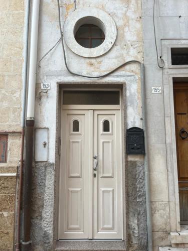 a white door in a stone building with a window at Casa Verde in Mesagne