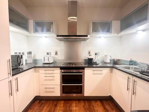 a kitchen with white cabinets and stainless steel appliances at NEW Two Bedroom Apartment with Balcony in London