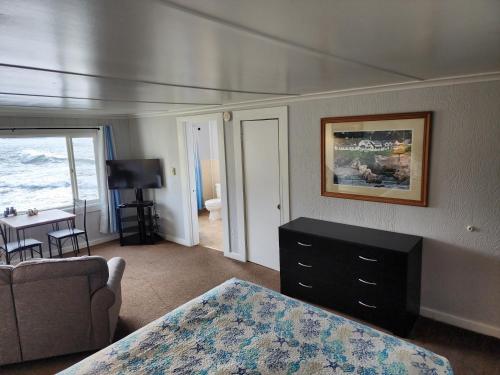a bedroom with a bed and a couch and a table at Inn at Arch Rock in Depoe Bay