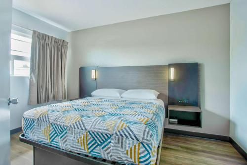 a bedroom with a bed with a colorful comforter at Motel 6-Bend, OR in Bend