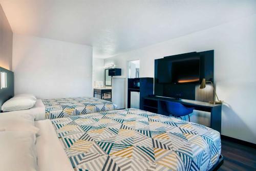 a bedroom with a bed and a desk and a television at Motel 6-Bend, OR in Bend