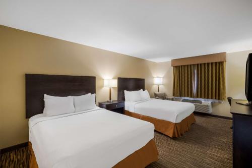 Habitación de hotel con 2 camas y TV en Best Western Gold Poppy Inn, en Tucson