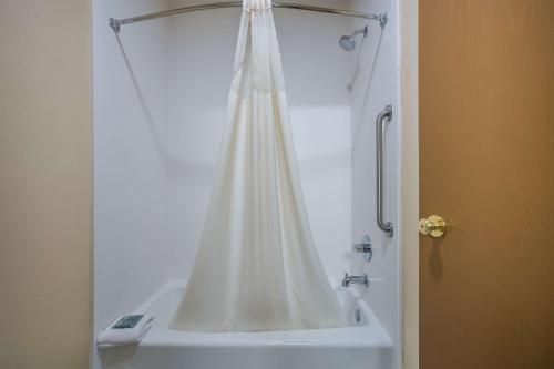 a shower with a white shower curtain in a bathroom at Best Western Gold Poppy Inn in Tucson