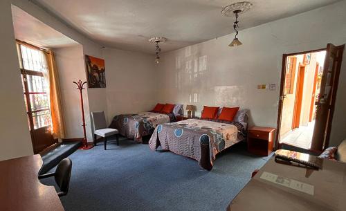 een slaapkamer met 2 bedden en een bank. bij Hostal Benalcazar in Quito