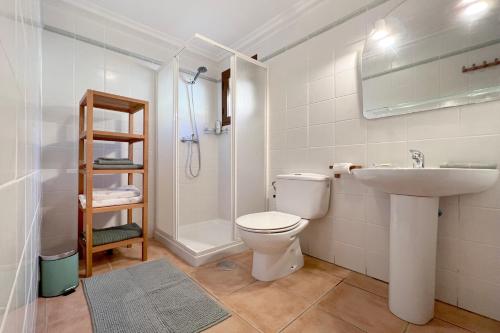 a bathroom with a toilet and a sink and a shower at Roda, Sea and Golf in Roda