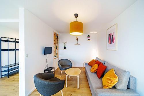 uma sala de estar com um sofá e uma mesa em Charmant 2 chambres rénové avec balcon-Oullins em Oullins