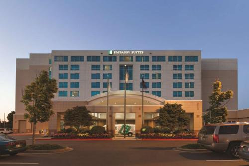 a building with a car parked in a parking lot at Embassy Suites by Hilton Portland Airport in Portland