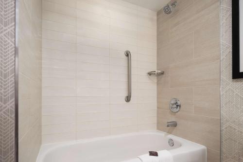 a white bath tub in a bathroom with a shower at Embassy Suites by Hilton Portland Airport in Portland