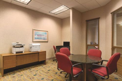 a waiting room with a table and red chairs at Embassy Suites by Hilton Portland Airport in Portland