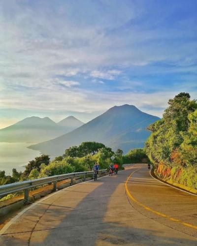 a group of people riding bikes down a road at Unicorn Reborn - Peaceful Rentals in San Marcos La Laguna