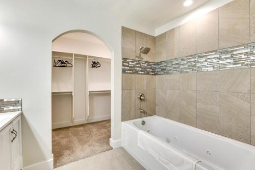 a white bathroom with a tub and a shower at Twin Falls Vacation Rental with Yard Less Than 3 Mi to Town! in Twin Falls
