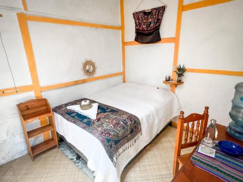 a small bedroom with a bed and a table at Unicorn Reborn - Peaceful Rentals in San Marcos La Laguna