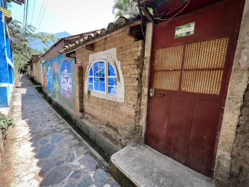 a red door on the side of a brick building at Unicorn Reborn - Peaceful Rentals in San Marcos La Laguna