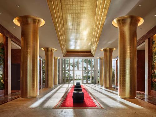 un pasillo con columnas y una alfombra roja en un edificio en Faena Hotel Miami Beach, en Miami Beach
