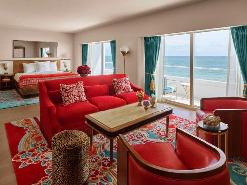Habitación de hotel con sofá rojo y cama en Faena Hotel Miami Beach, en Miami Beach