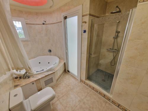 y baño con ducha, aseo y lavamanos. en Villa Habibi Luxury 5A, en Chayofa