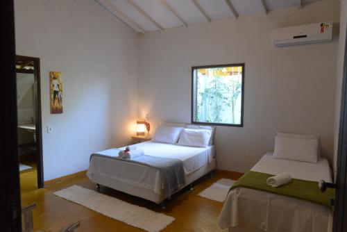 1 dormitorio con 2 camas y ventana en Casa Franco Hospedaria, en Trancoso