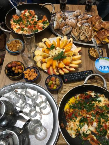 uma mesa com muitos tipos diferentes de alimentos sobre ele em Moroccan Family House em Agadir