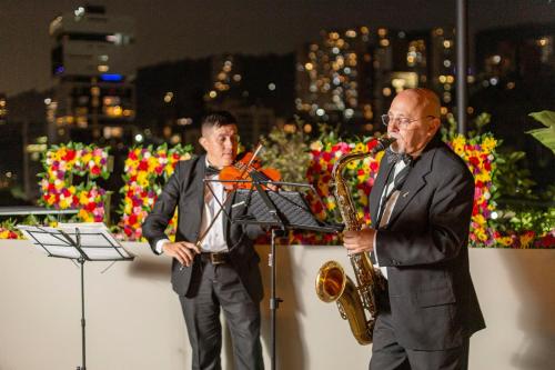 two men in suits playing music and a trumpet at 1616 Hotel in Medellín