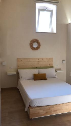 sypialnia z dużym białym łóżkiem i oknem w obiekcie Castrum Rooms w mieście Mesagne