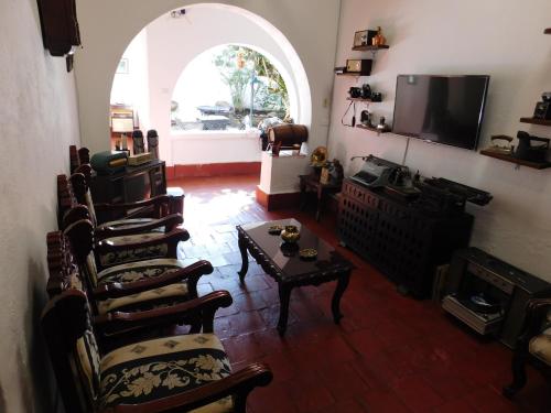 sala de estar con sillas, mesa y TV en Casa Hotel Paraíso Bella Villa en Villa de Leyva