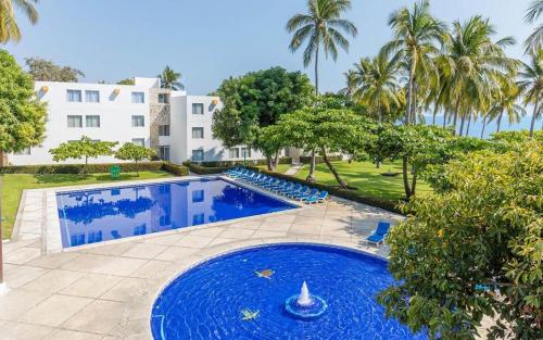 a pool with blue water in front of a building at Posada Real Puerto Escondido in Puerto Escondido