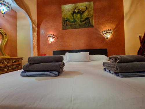 um quarto com uma grande cama branca com toalhas em Villa Habibi Luxury 5B em Chayofa