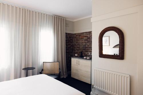 a bedroom with a bed and a mirror on the wall at Links House in Bowral
