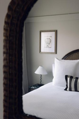 a bedroom with a bed and a table with a lamp at Links House in Bowral