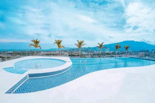 uma piscina com palmeiras e uma cidade em SuiteGreen, exclusivo apartaestudio !! em Ibagué