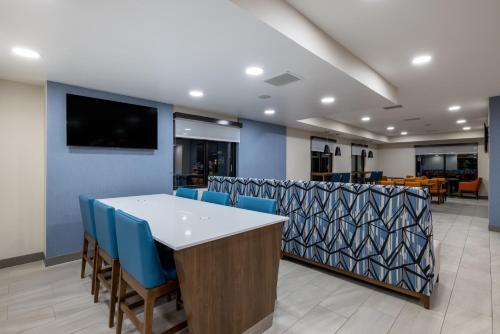 a conference room with a table and blue chairs at Holiday Inn Express Rochester South - Mayo Area by IHG in Rochester