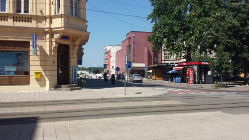 an empty city street with buildings and a tree at Apartment Travego II in Osijek
