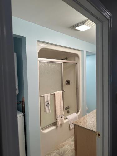 La salle de bains est pourvue d'une douche et de serviettes sur un miroir. dans l'établissement Claddagh Cottage, à Richfield Springs