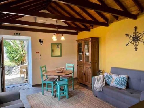 - un salon avec une table, des chaises et un canapé dans l'établissement Casa do Laureano, à Santo Amaro