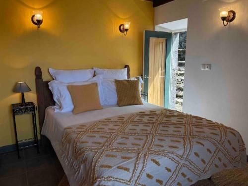1 dormitorio con 1 cama grande con almohadas blancas en Casa do Laureano, en Santo Amaro