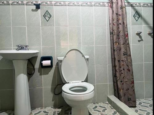 a bathroom with a toilet and a sink at Hermosa vista, casa en Boquete. in Boquete