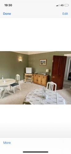 a living room with a table and a table and chairs at The Old Manse B&B in Thurso