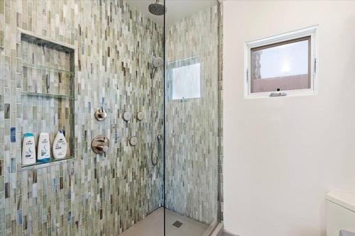 a shower with a glass door in a bathroom at Craftsman Bungalow- University Heights 2BR Home in San Diego