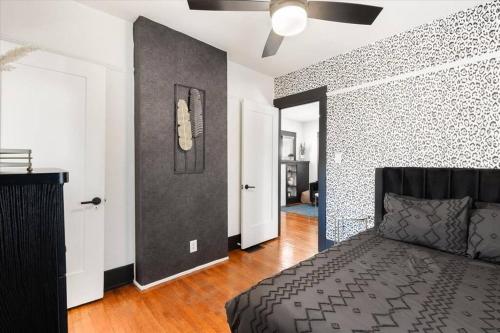a bedroom with a black bed and a wall at Craftsman Bungalow- University Heights 2BR Home in San Diego