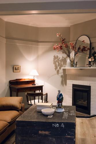 a living room with a couch and a fireplace at Links House in Bowral