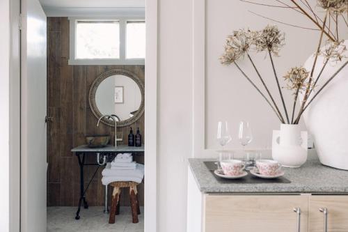 um corredor com uma mesa com um espelho e um vaso com flores em Links House em Bowral