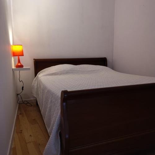 - une chambre avec un lit et une lampe au sol dans l'établissement Gite du colombier, à Usson