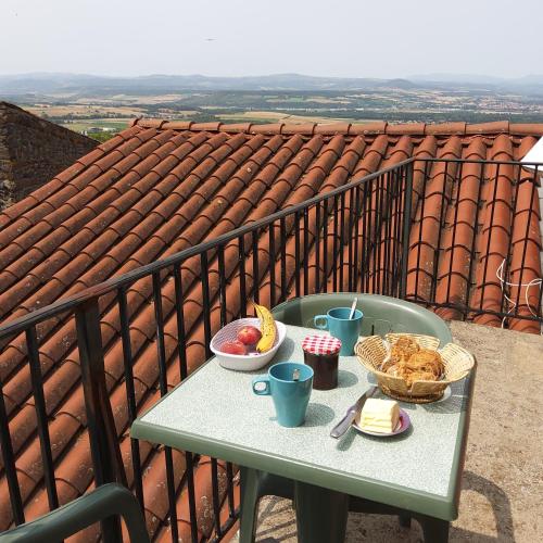 une table avec de la nourriture au sommet d'un balcon dans l'établissement Gite du colombier, à Usson