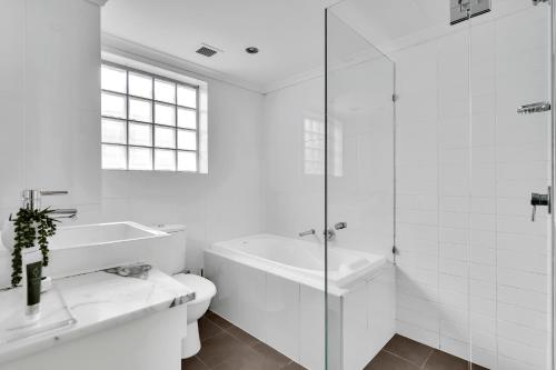 La salle de bains blanche est pourvue d'une baignoire, de toilettes et d'un lavabo. dans l'établissement Spacious Two bedroom apartment - St Leonards AL25, à Sydney