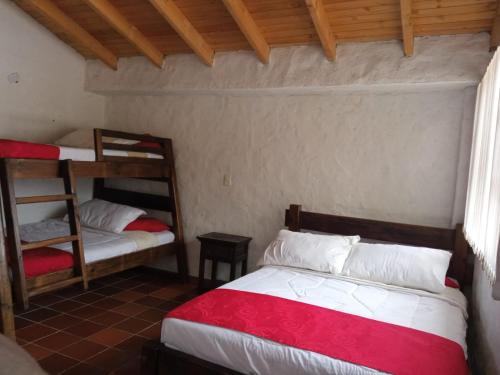 a bedroom with two bunk beds and a ladder at Hotel Lancers - Pantano de Vargas in Paipa