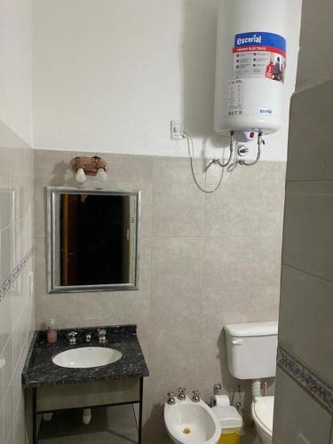 ein Bad mit einem Waschbecken, einem WC und einer Klimaanlage in der Unterkunft Glamping Urbano Posadas in Posadas