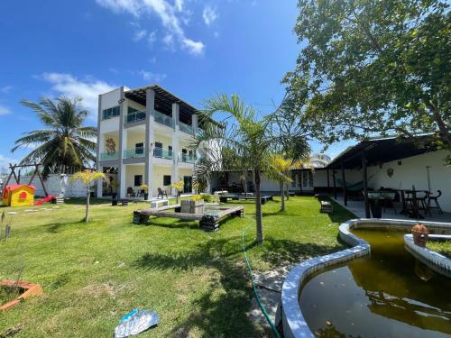 圣阿马鲁Eco House Gaivota - Cond Ville Portal das Dunas的前面有池塘的房子
