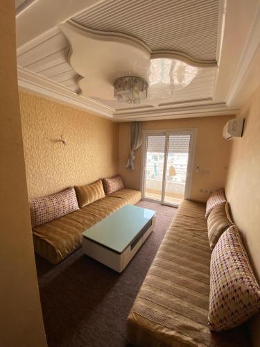 una sala de estar con un sofá y una mesa en Appart centre ville, en Agadir
