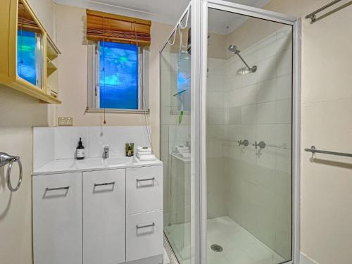 La salle de bains est pourvue d'une douche et d'un lavabo. dans l'établissement Picnic Bay Apartments Unit 1, à Picnic Bay