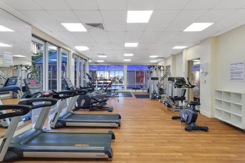 a gym with rows of treadmills and elliptical machines at Holiday Holiday Chevron Renaissance Apartments in Gold Coast